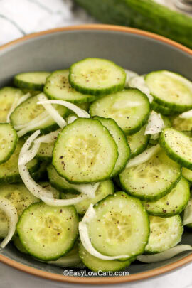 close up of a bowl of cucumber and onion salad.