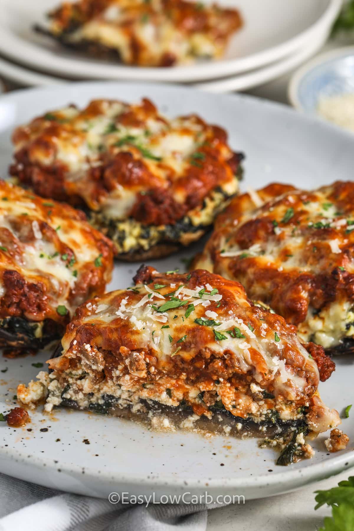 Lasagna Stuffed Mushrooms on a plate with a piece taken out of one