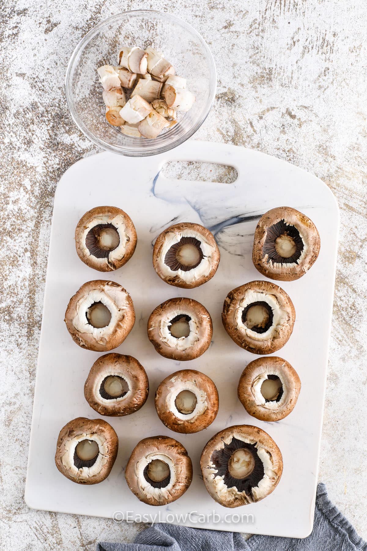 scooping out stems of mushrooms to make Air Fryer Stuffed Mushrooms