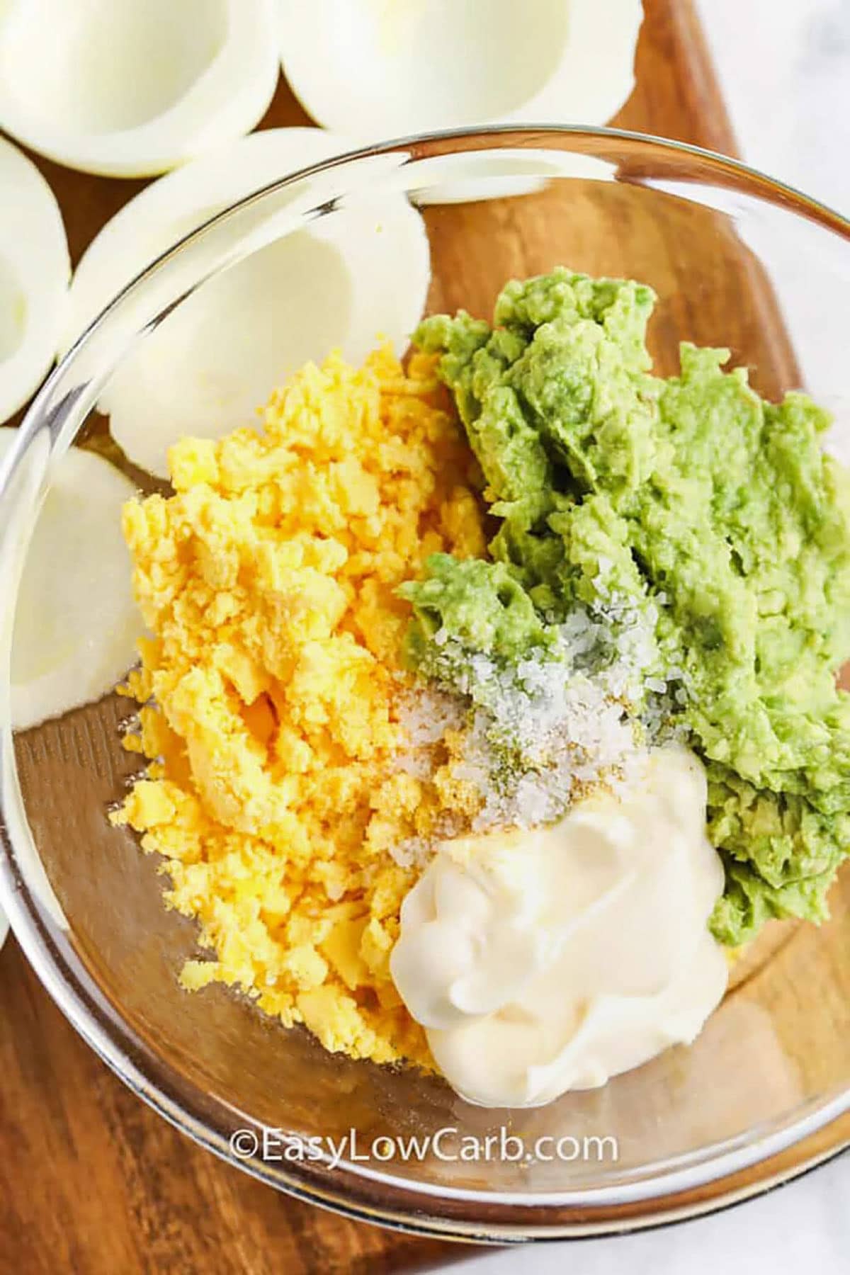 adding ingredients to bowl to make filling for Avocado Deviled Eggs