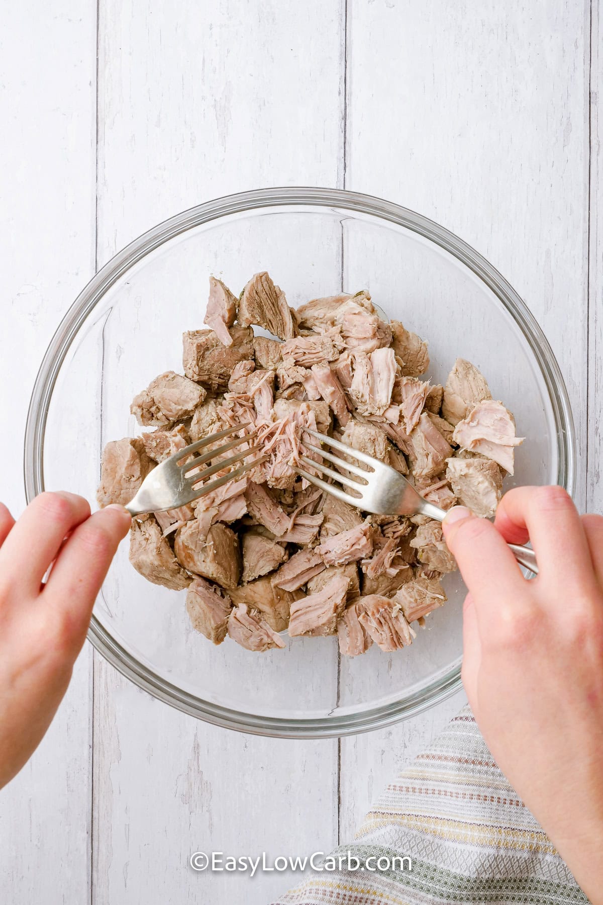 shredding pork with a fork to make Shredded Pork Tacos