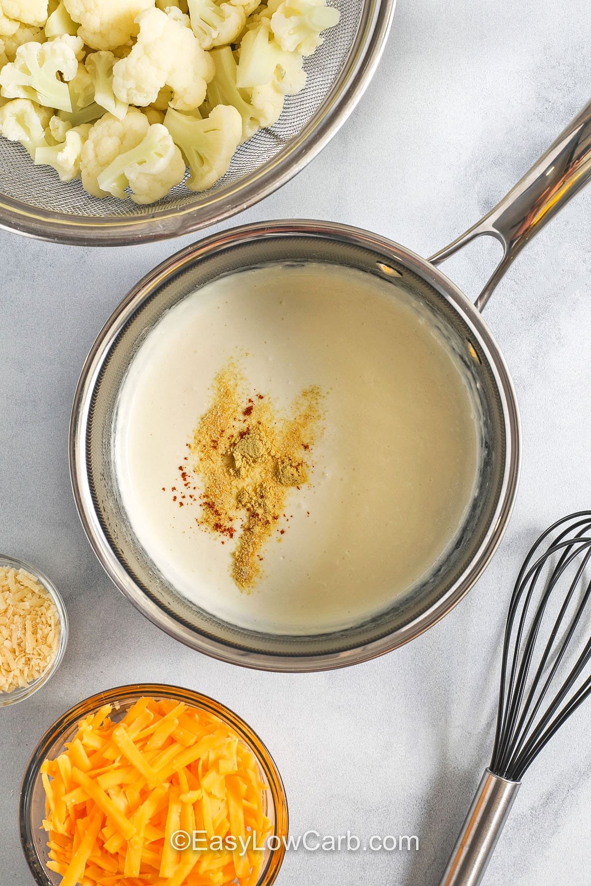 adding seasonings to cream in the pan to make Cheesy Cauliflower Casserole