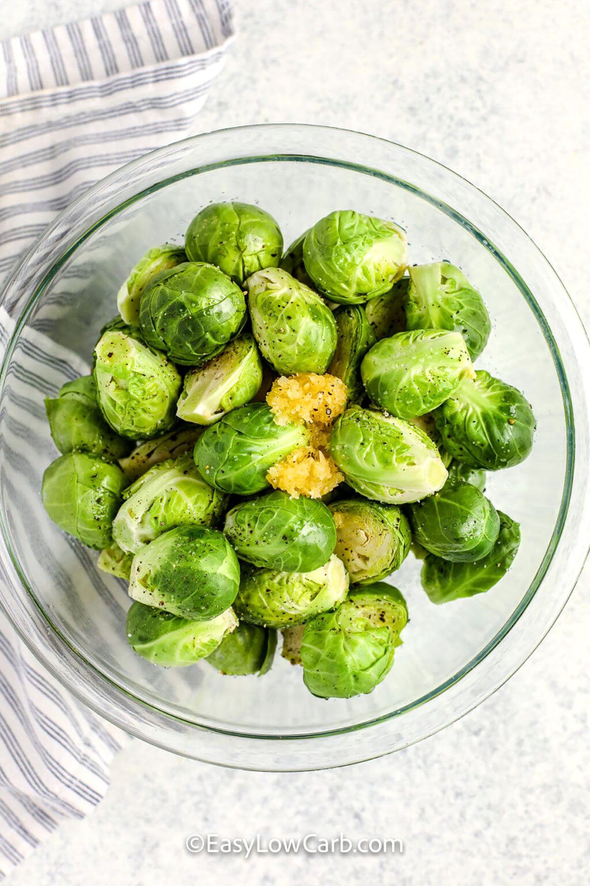 adding seasoning to brussels to make Grilled Brussels Sprouts