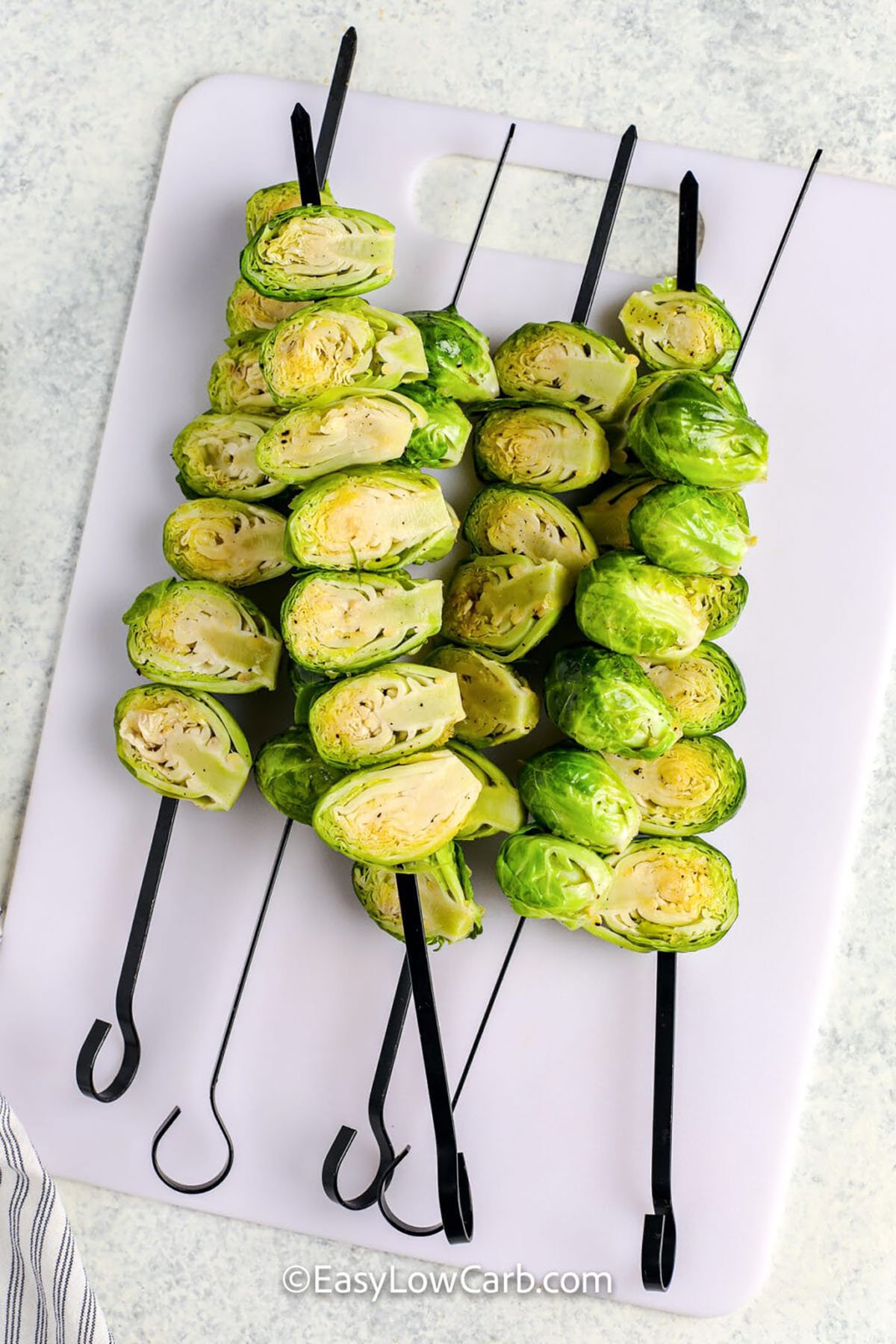brussels on skewers before cooking to make Grilled Brussels Sprouts