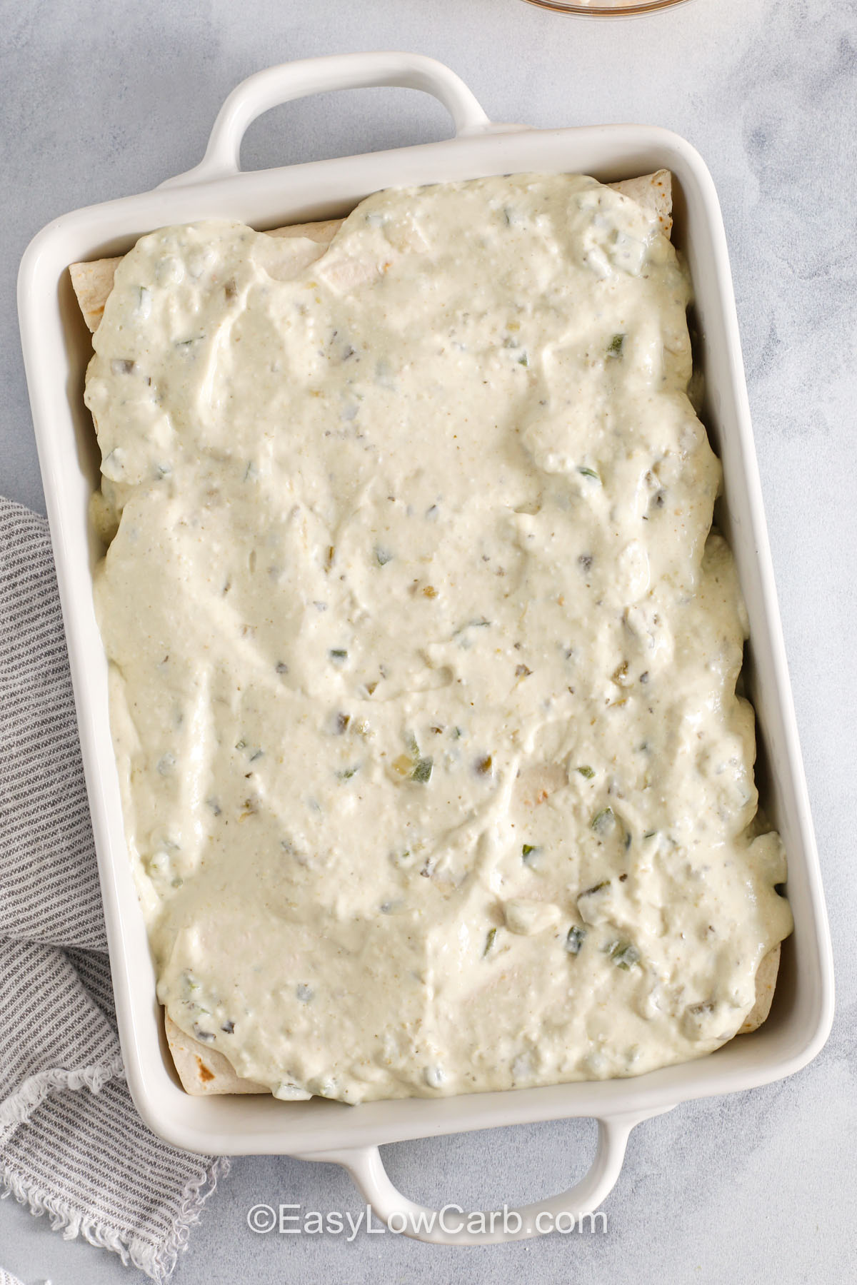 adding sauce to Creamy Chicken Enchiladas