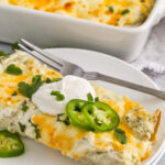 close up of Creamy Chicken Enchiladas with one on a plate