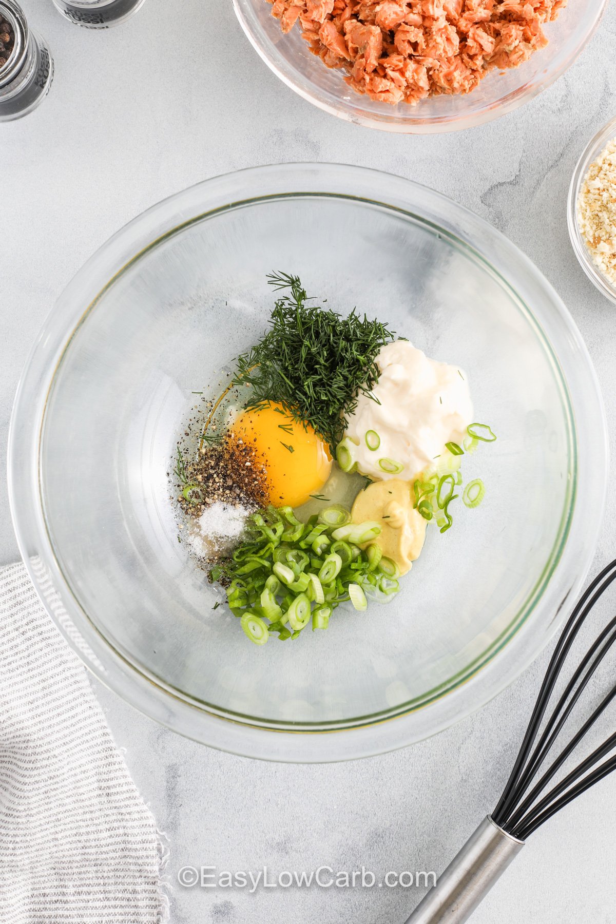 adding ingredients to bowl to make Keto Salmon Patties