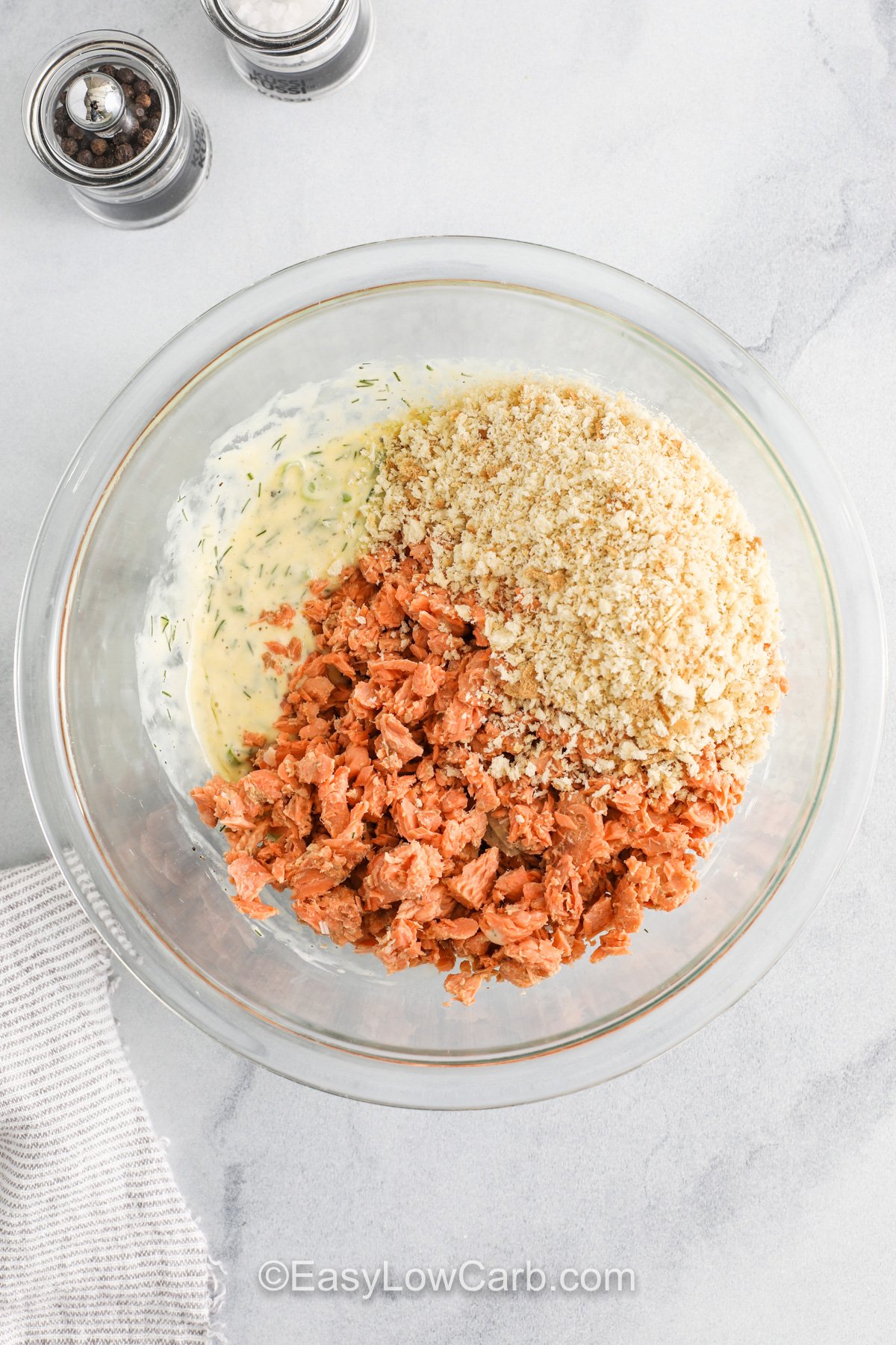 Combining bread crumbs with other ingredients in bowl to make Keto Salmon Patties