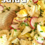 Cauliflower Potato Salad in a bowl with a wooden spoon
