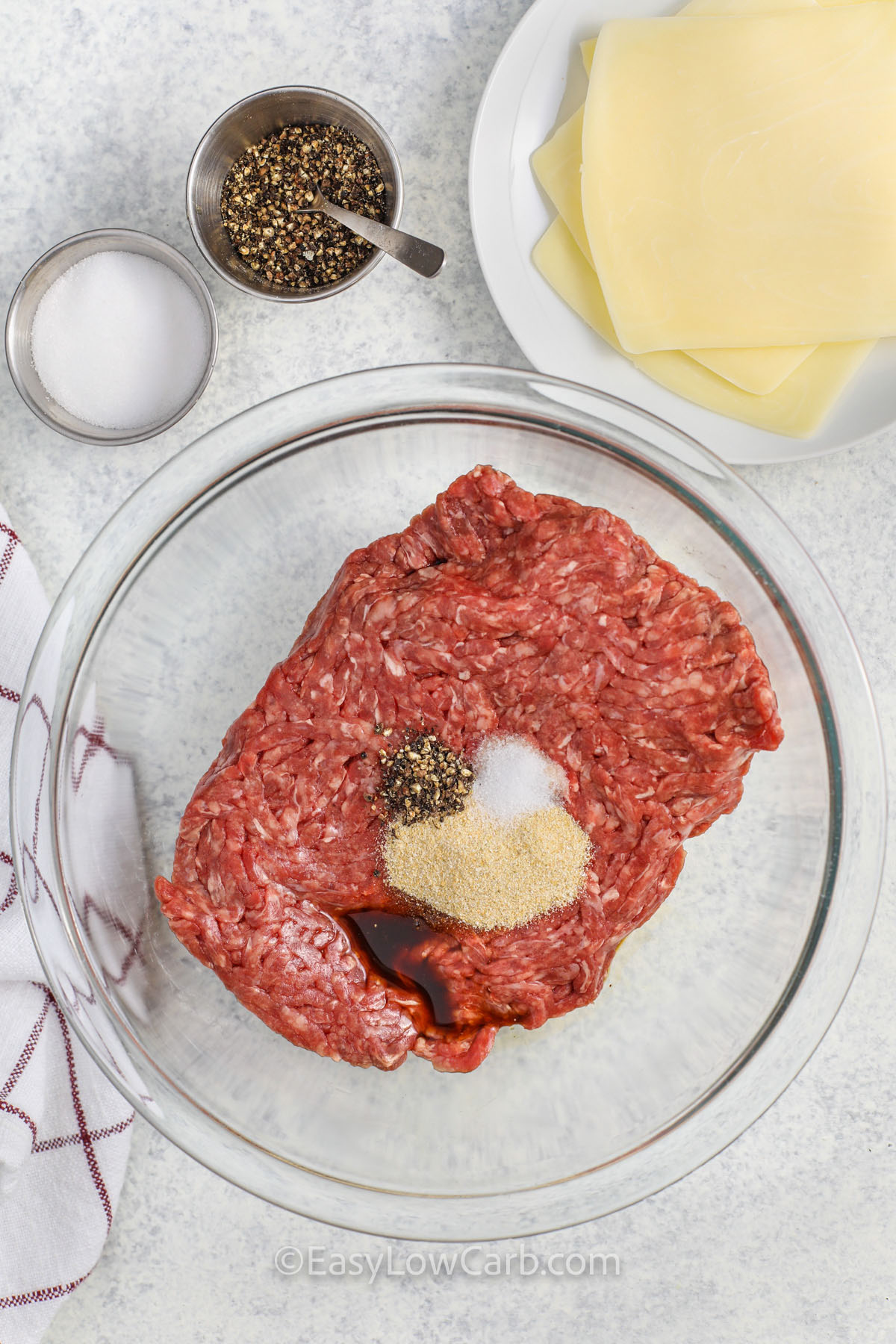 adding seasonings to beef to make Cheese Stuffed Burgers