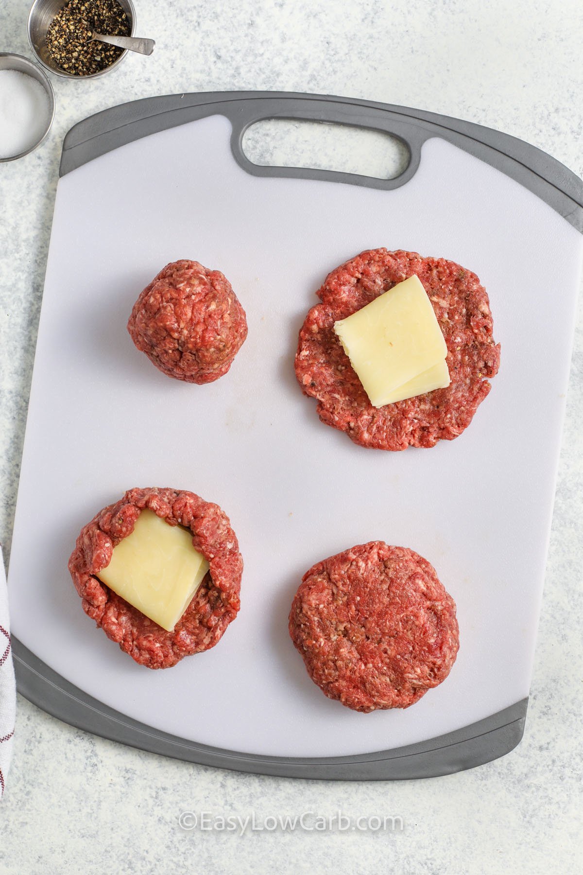 adding cheese to hamburger patties to make Cheese Stuffed Burgers