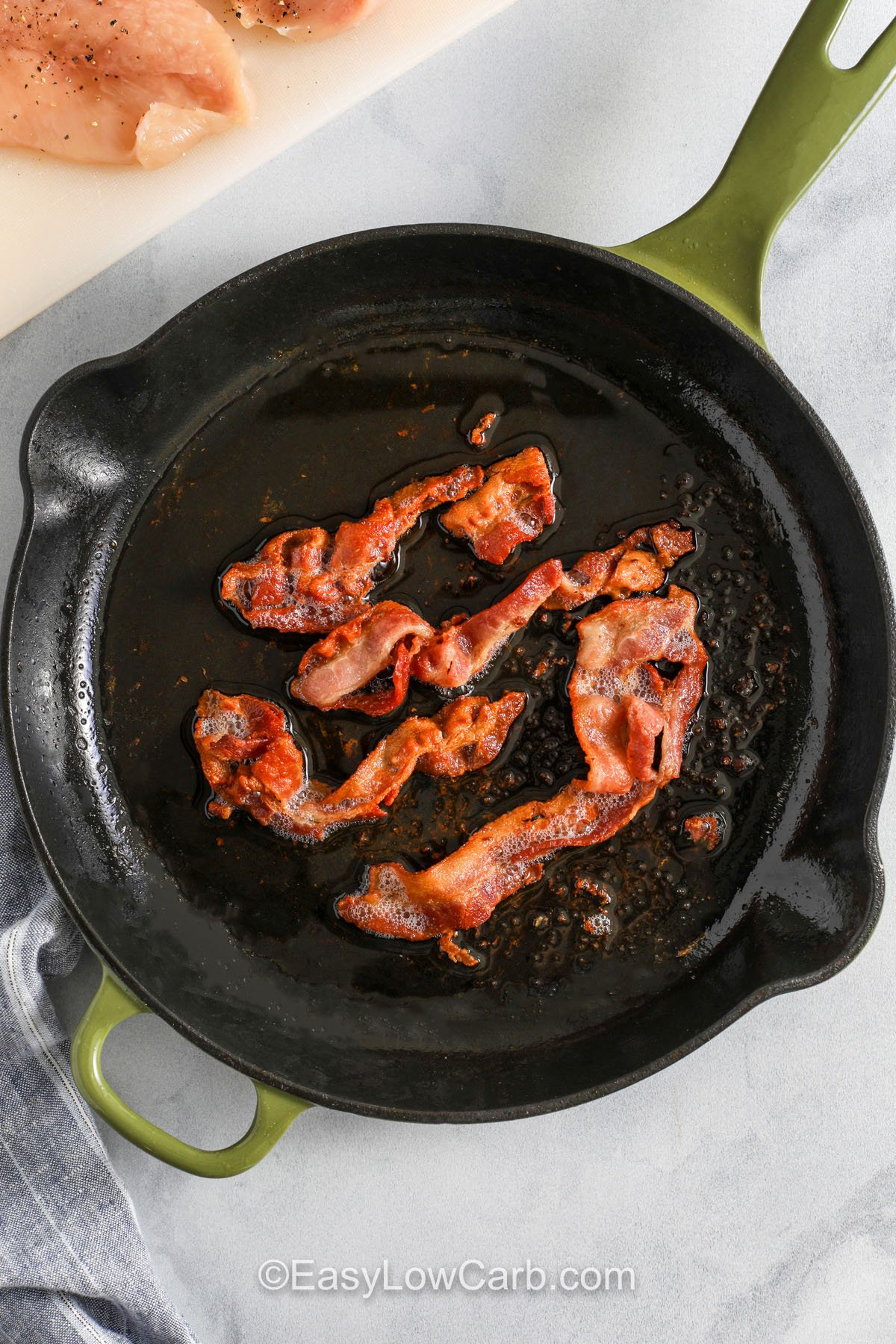 crispy bacon cookin in a pan to make Bacon Ranch Chicken