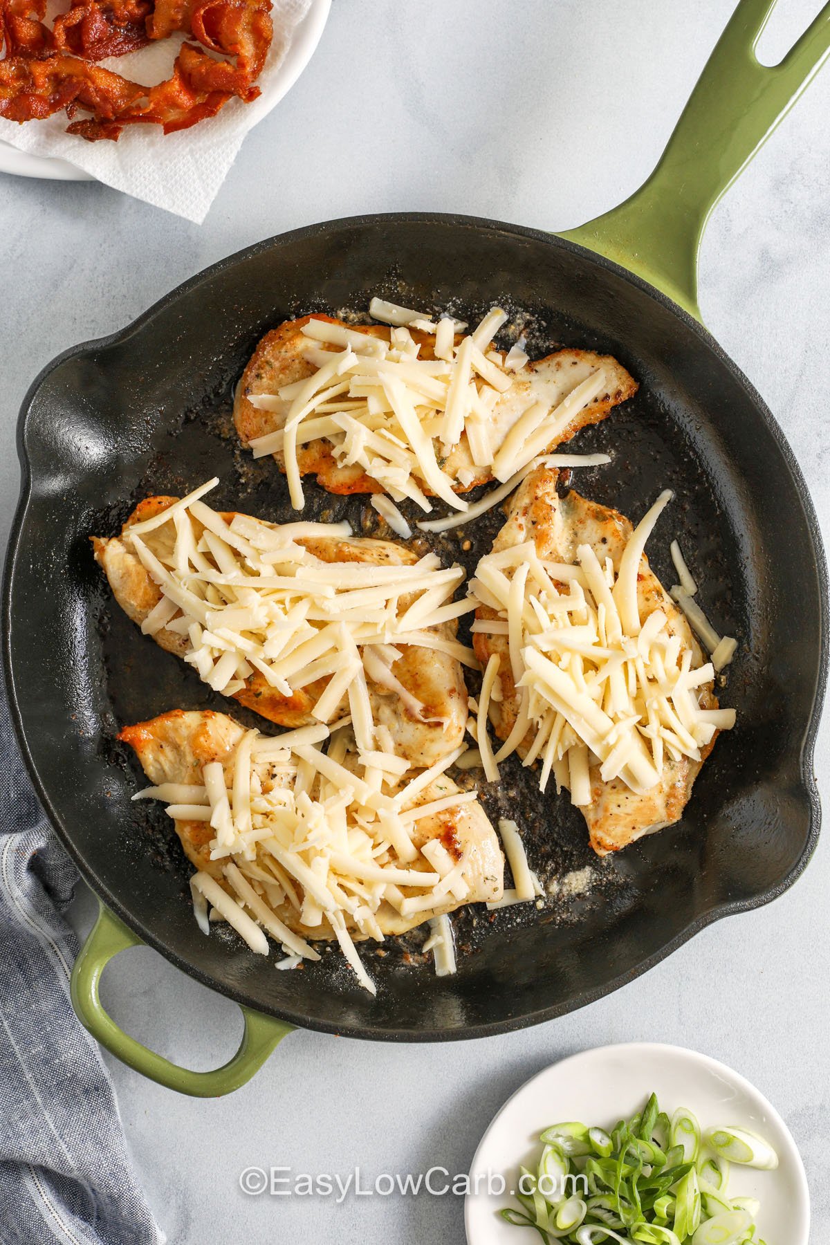 adding cheese on top of chicken to make Bacon Ranch Chicken