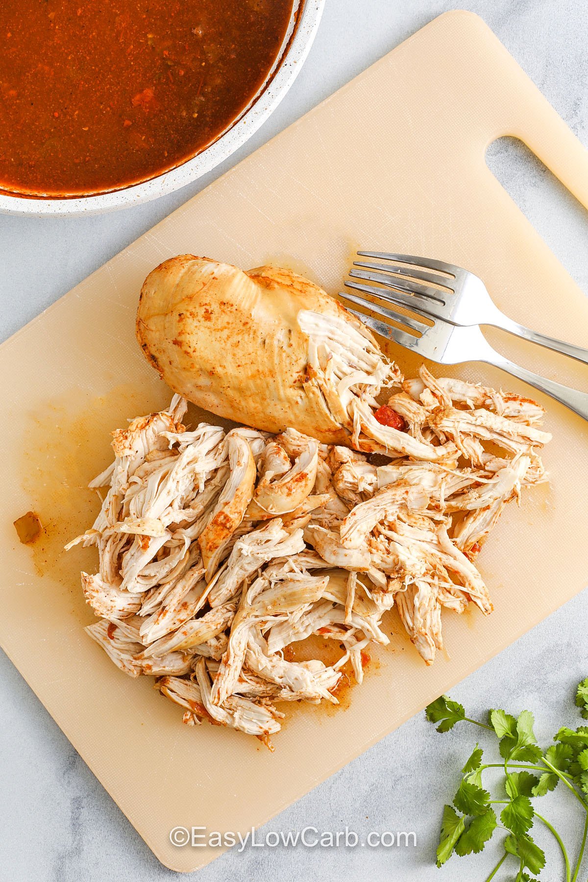 shredding chicken with fork to make Recipe for Chicken Tacos