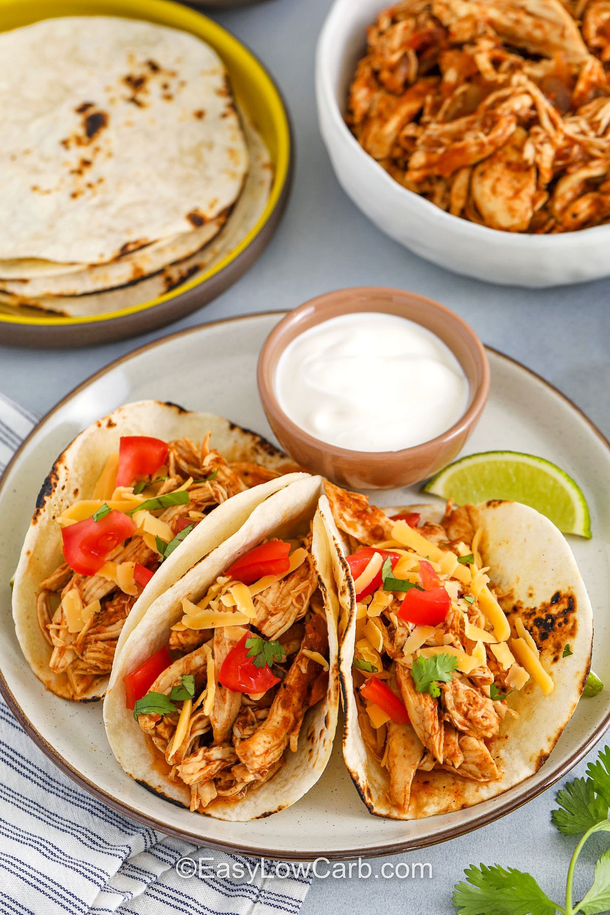 Chicken Tacos with cheese on a plate with sour cream dip