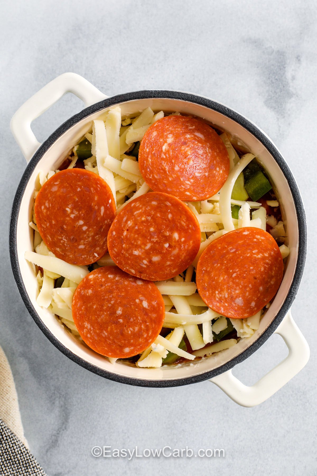 adding cheese and pepperoni to dish to make Cottage Cheese Pizza