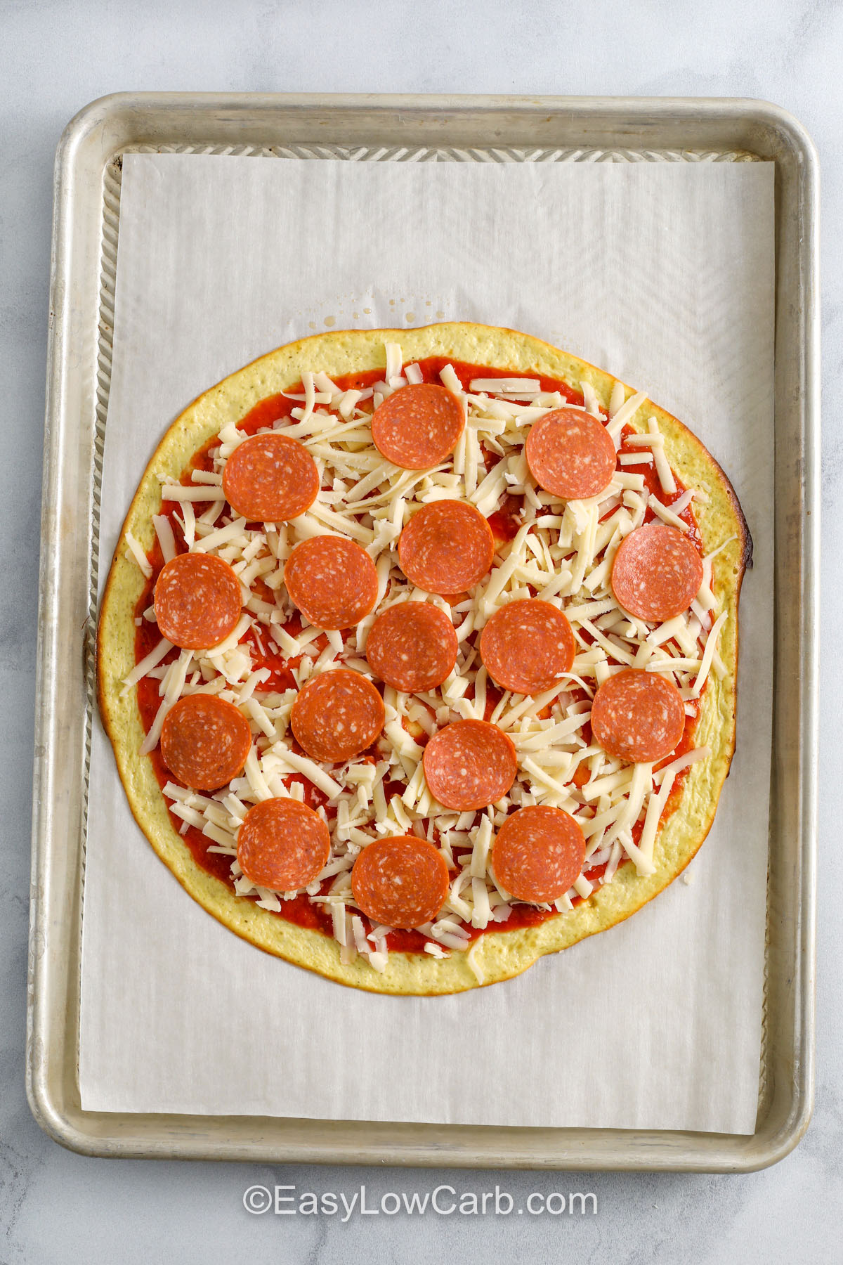adding pepperoni and cheese to Cottage Cheese Pizza before baking