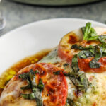 caprese chicken on a plate with text