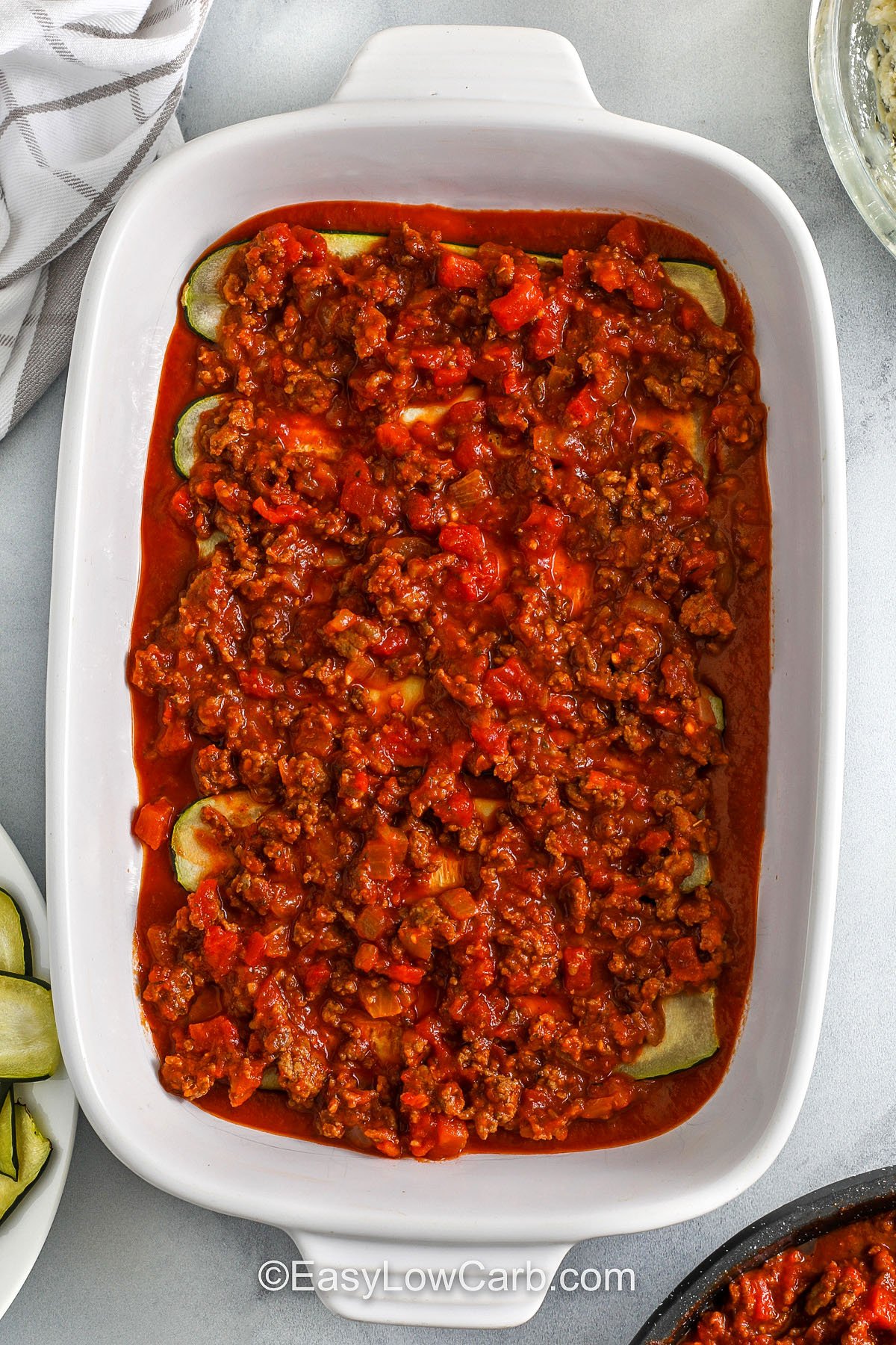 adding meat sauce to zucchini to make zucchini lasagna recipe