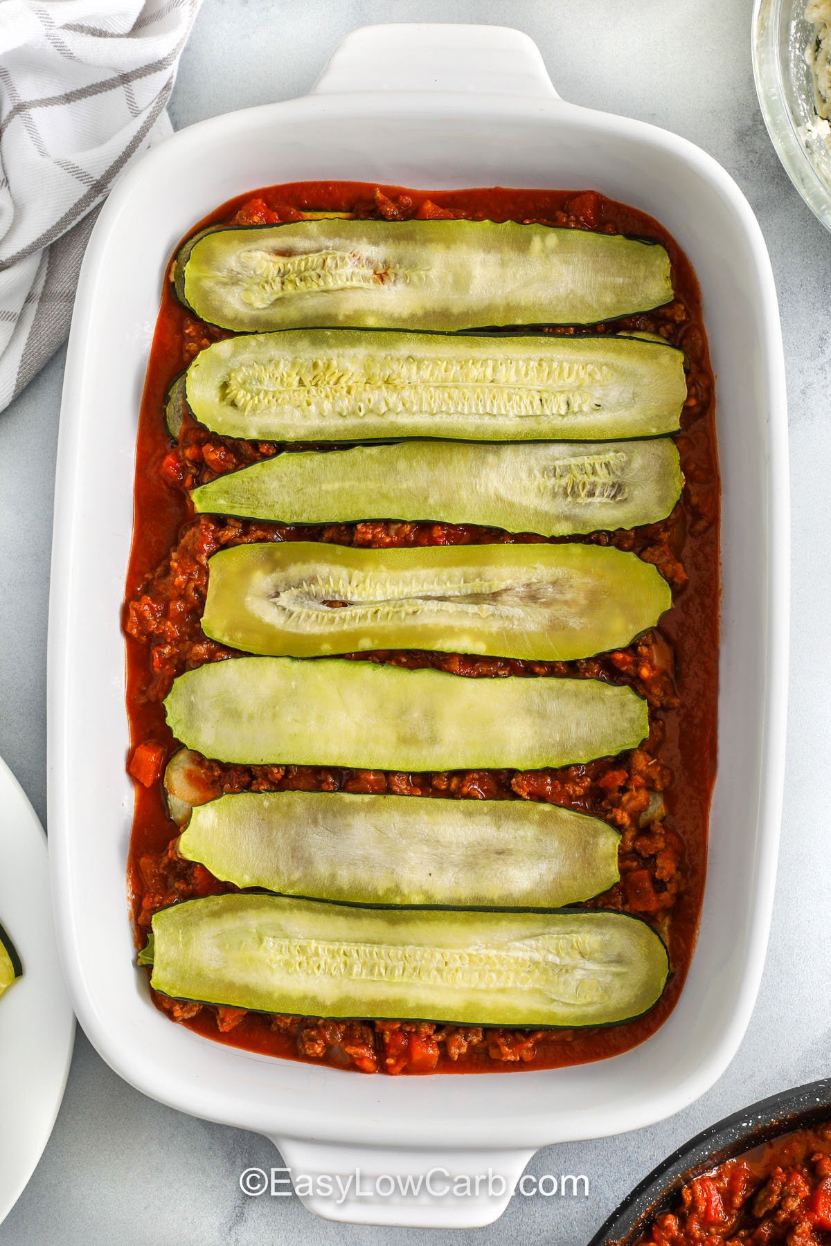 adding zucchini on top of meat sauce layer to make zucchini lasagna recipe