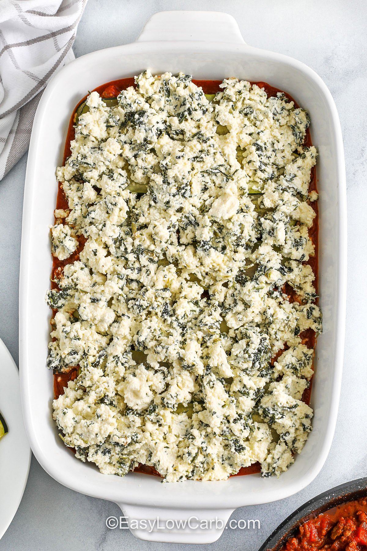 adding cottage cheese and spinach layer to dish to make zucchini lasagna recipe