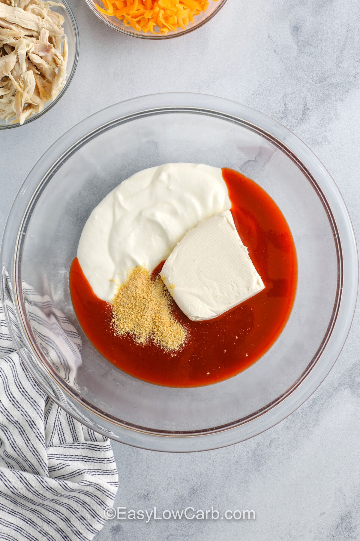 adding ingredients together to make Cottage Cheese Buffalo Chicken Dip