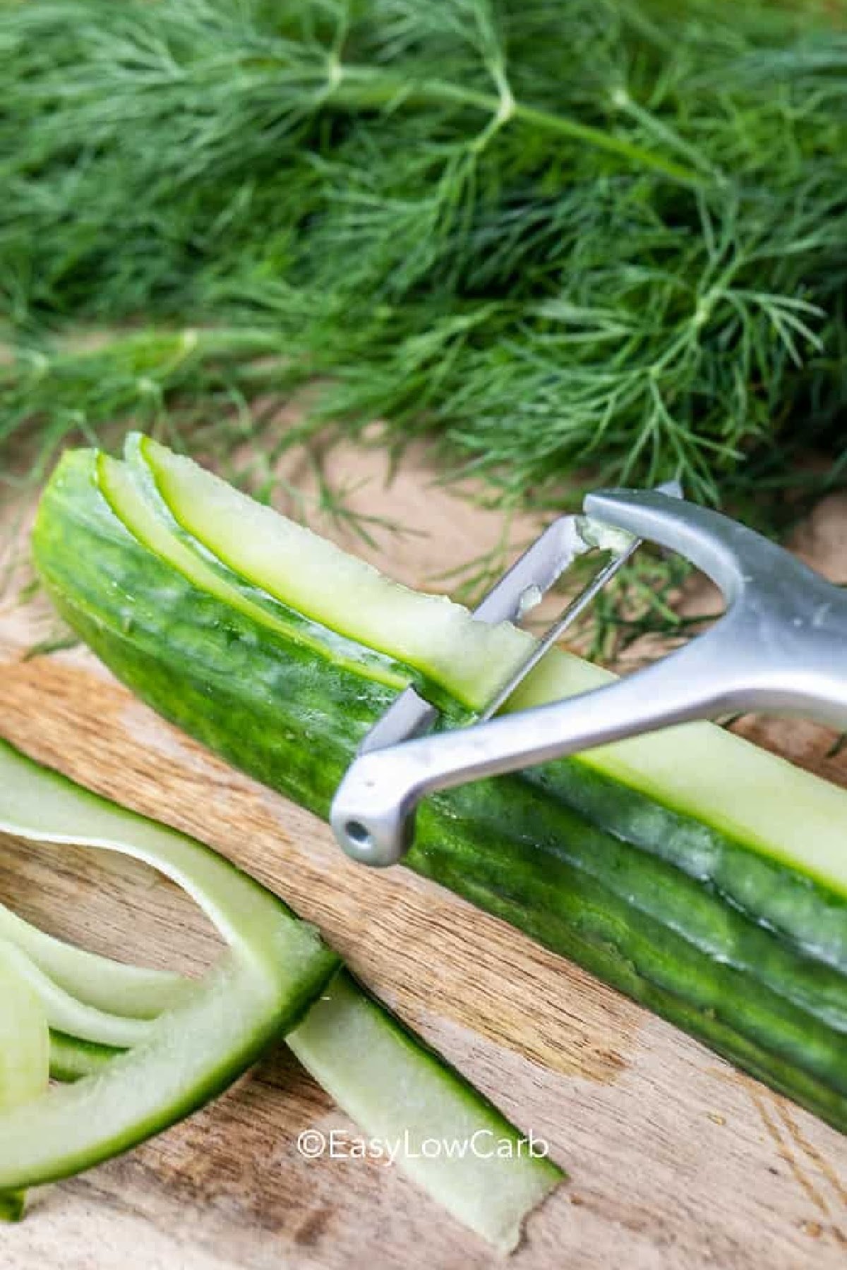a vegetable peeler slicing cucumber ribbons