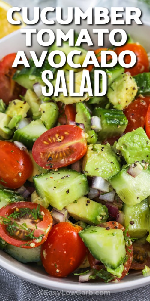 Cucumber tomato avocado salad in a bowl with writing