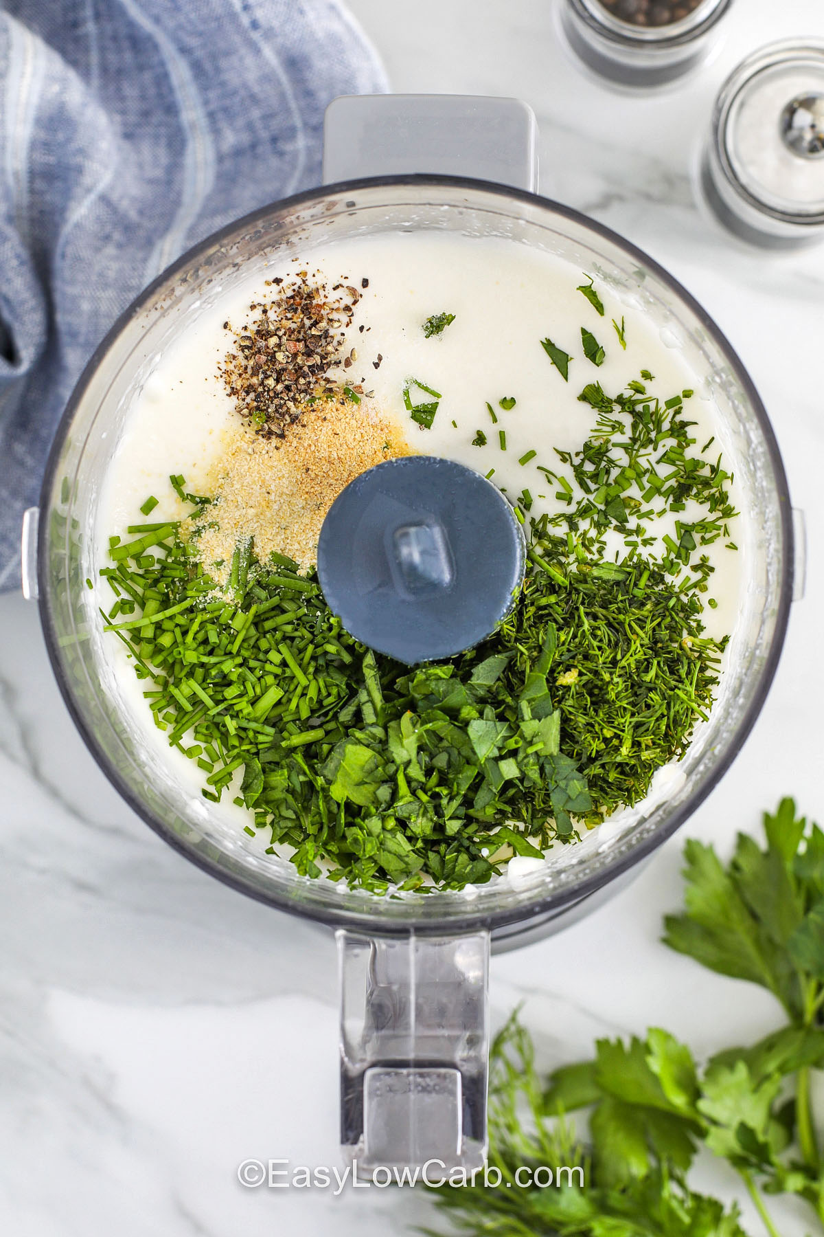 adding ingredients to blended cottage cheese mixture to make Cottage Cheese Ranch Dip