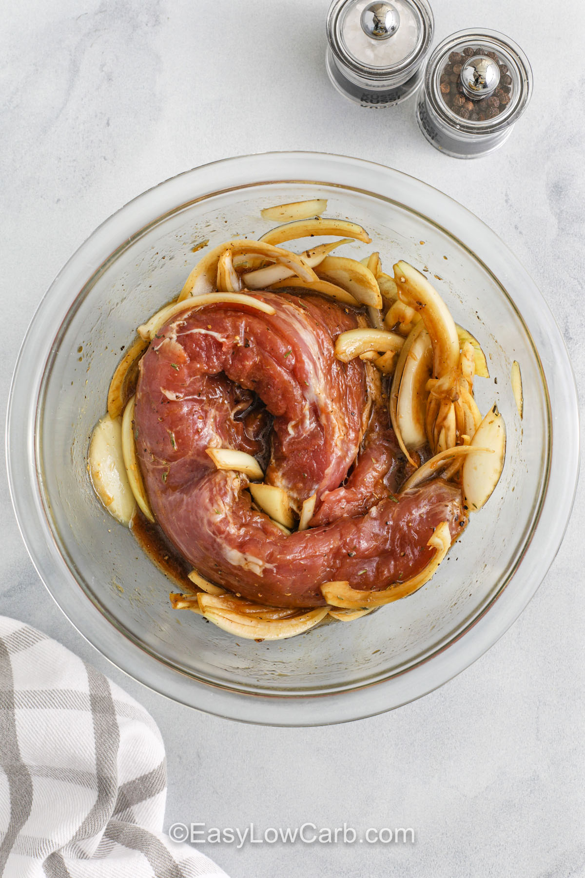 Easy to prepare and packed with flavor, this grilled pork tenderloin recipe is perfect for any occasion. The savory marinade penetrates the meat for maximum taste, while grilling adds irresistible char. Optional sugar-free apricot glaze adds a subtle sweetness that complements the smoky flavor beautifully. A wholesome low-carb favorite for your grill nights. #easylowcarb pork tenderloin in marinade with onions to make Grilled Pork Tenderloin