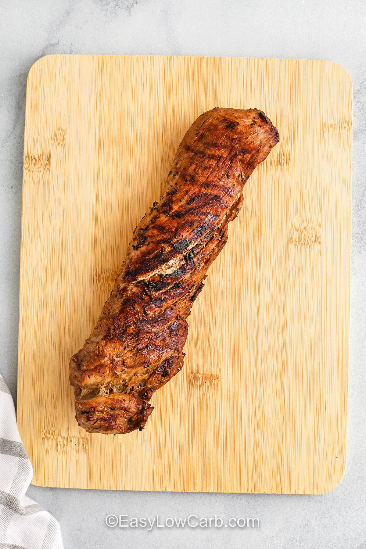 This grilled pork tenderloin recipe is simple yet flavorful, making it a go-to for low-carb grilling. The marinade enhances tenderness while locking in deep savory flavor. Indirect heat ensures juicy results every time, and the optional glaze gives it a touch of sweetness without sugar. Serve sliced alongside crisp veggies for a light, delicious dinner. #easylowcarb cooked Grilled Pork Tenderloin on a cutting board