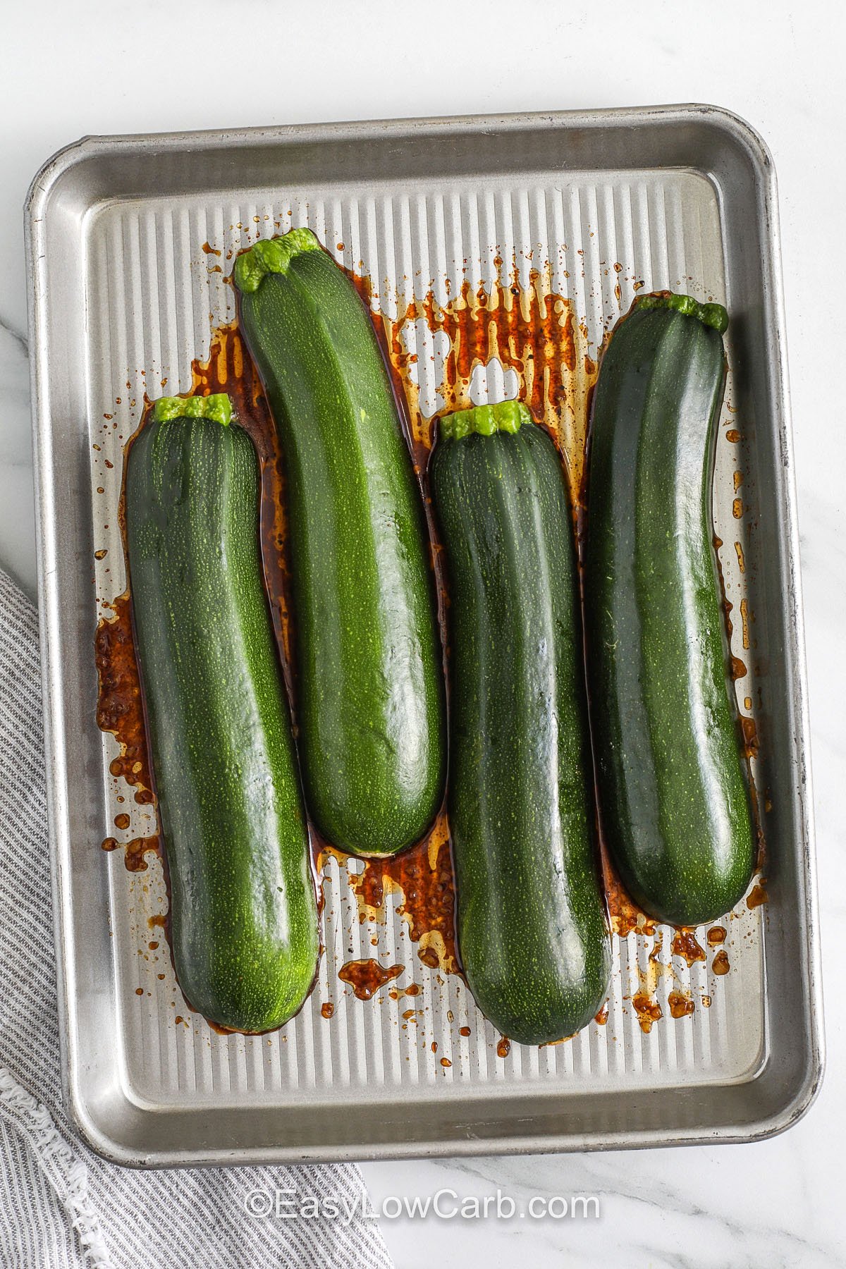 adding zucchini to sheet pan to make Zucchini Steaks