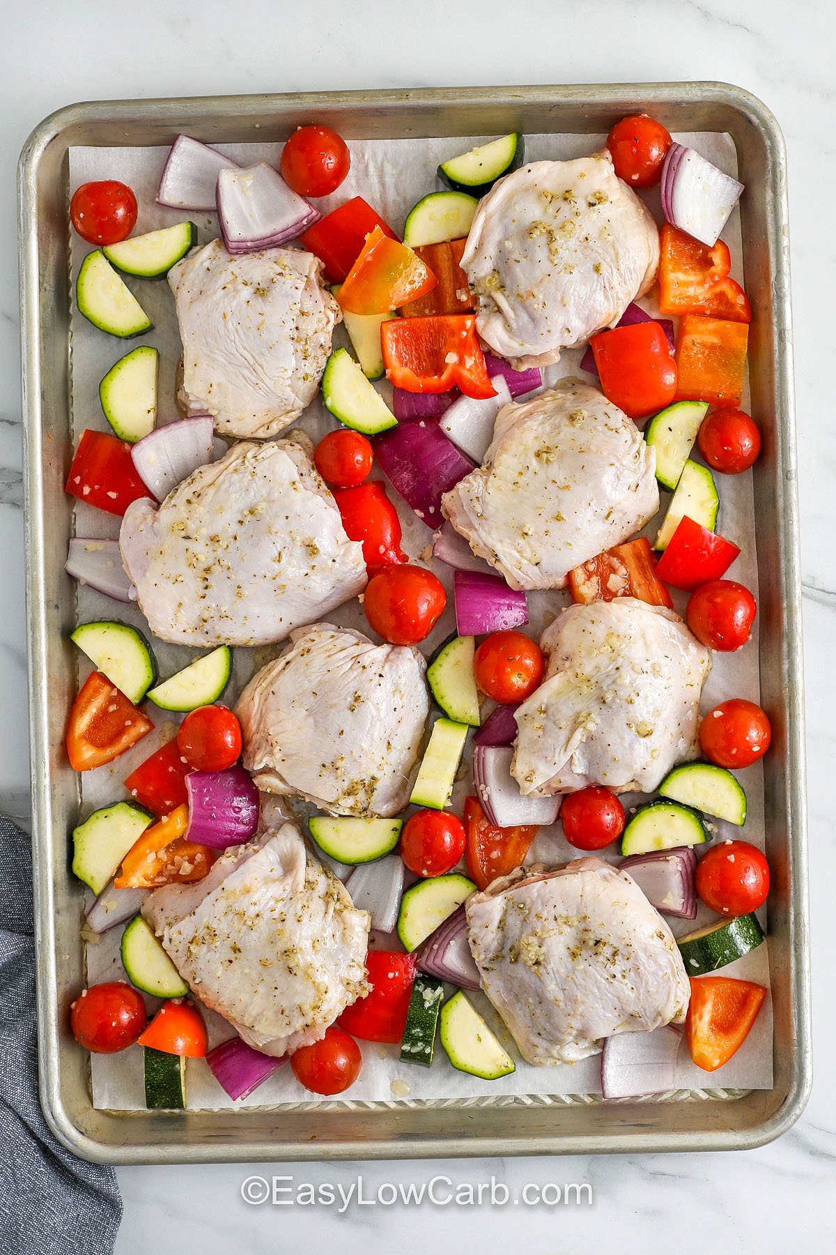 chicken and veggies on a sheet pan to make Greek Sheet Pan Chicken