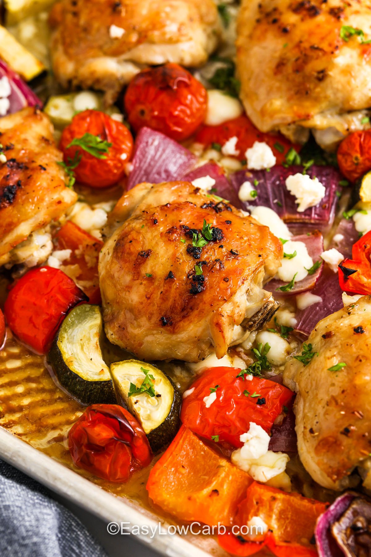 close up of baked Greek Sheet Pan Chicken with vegetables