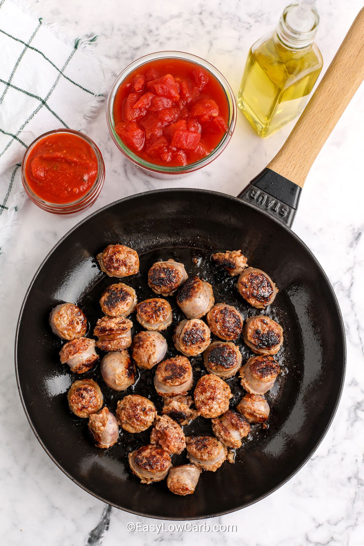 cooking italian sausages in pan to make Italian Sausage and Peppers