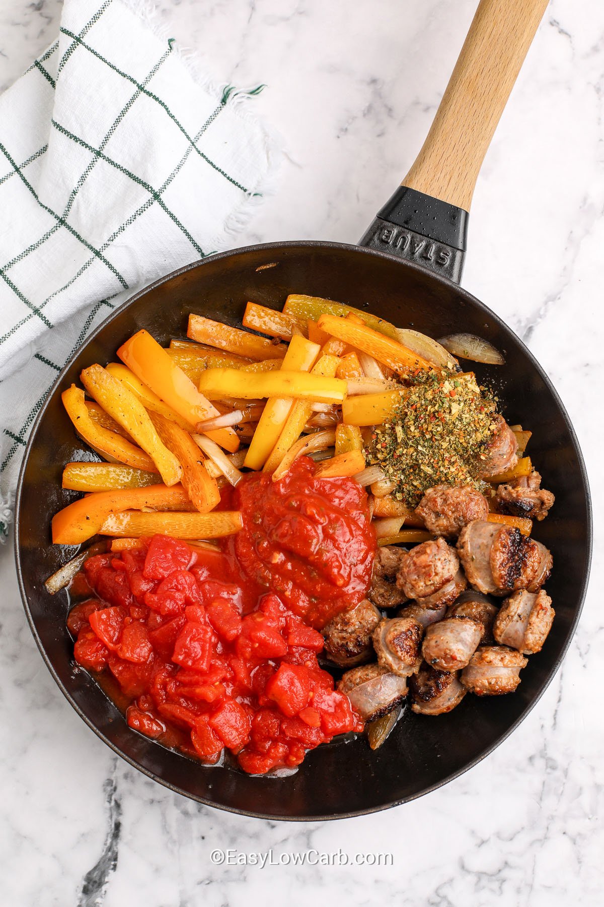 adding ingredients together in pan to make Italian Sausage and Peppers