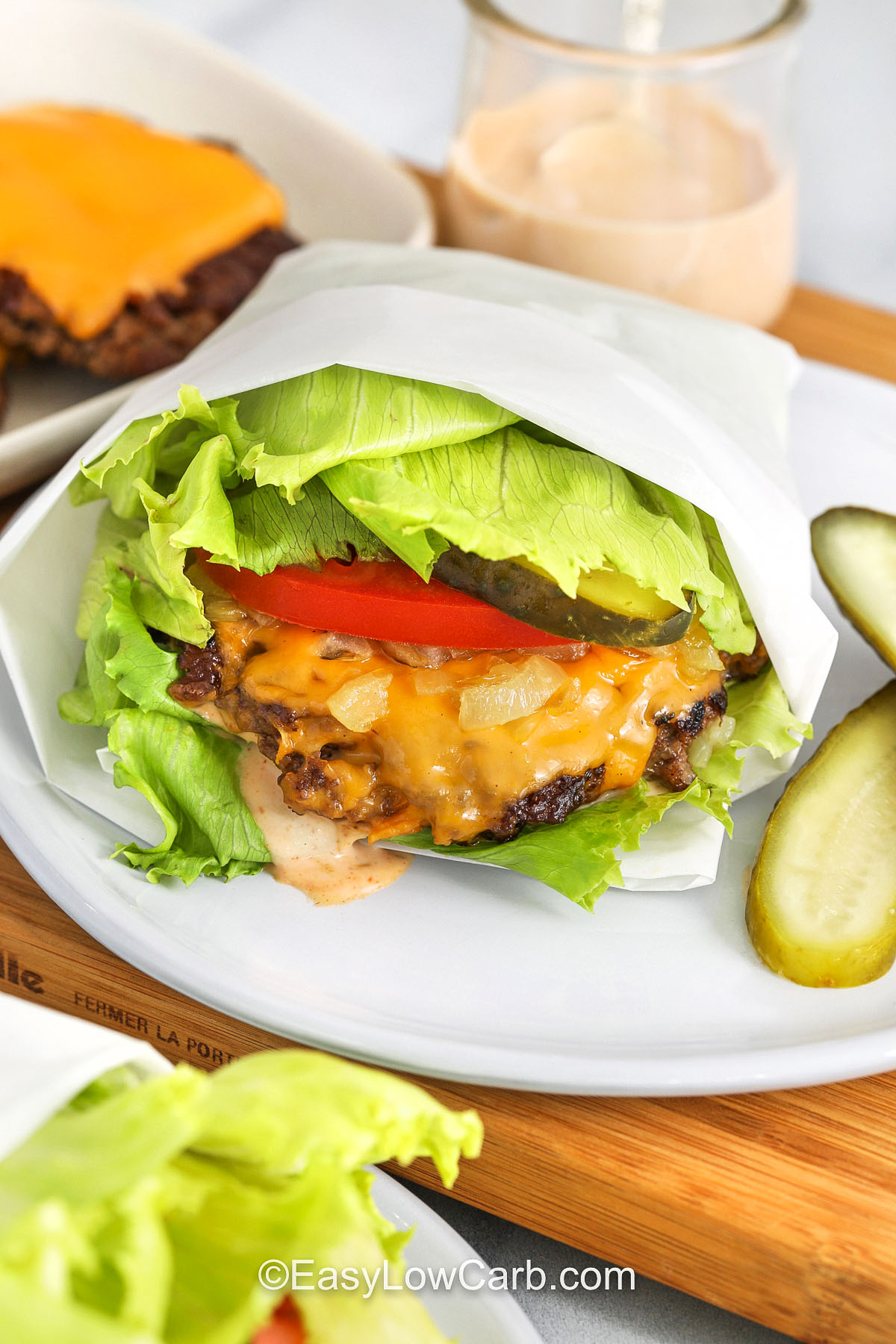 plate of Lettuce Wrapped Burger with butgers and cheese on a plate in the back