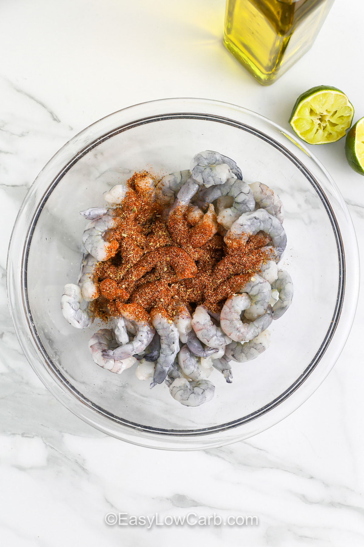 Sheet pan shrimp fajitas are an incredibly easy and delicious recipe for a low-carb, flavorful meal. The bell peppers, onions, and shrimp all roast together in the oven with fajita seasoning for a perfect balance of savory, spicy, and sweet. You can serve them with low-carb tortillas, lettuce wraps, or cauliflower rice for a versatile, satisfying meal prep option. A perfect dinner for busy weeknight cooking! #easylowcarb adding seasoning to shrimp to make Sheet Pan Shrimp Fajitas