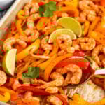 close up of Sheet Pan Shrimp Fajitas on a sheet pan with a spoon
