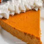 a slice of keto pumpkin pie with whipped cream