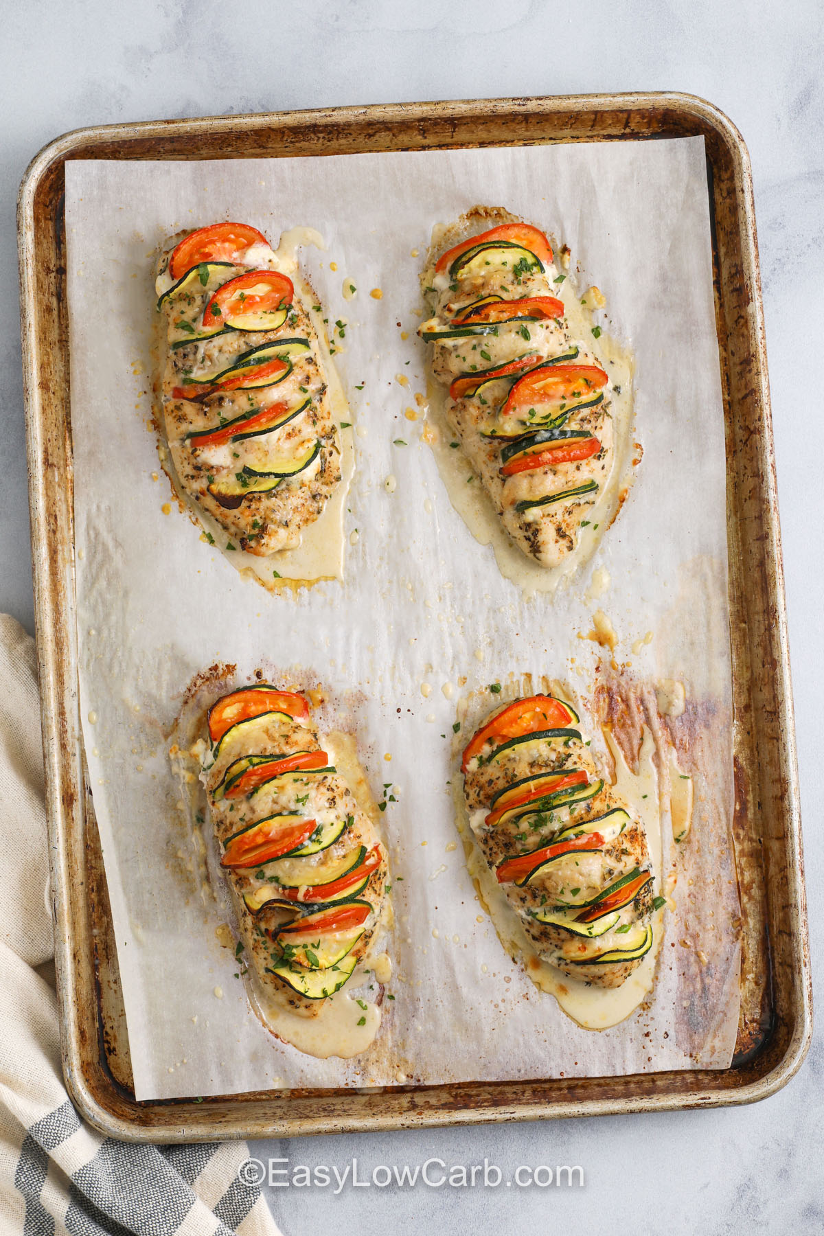 Hasselback chicken is an easy way to turn everyday ingredients into a low-carb dish that wows guests. The combination of juicy chicken, rich cream cheese, and crisp veggies makes it flavorful and satisfying. With minimal hands-on time and just one baking sheet, you’ll have a beautiful dinner with very little cleanup. Perfect for those following a keto or low-carb plan. #easylowcarb Hasselback chicken baked on a baking sheet