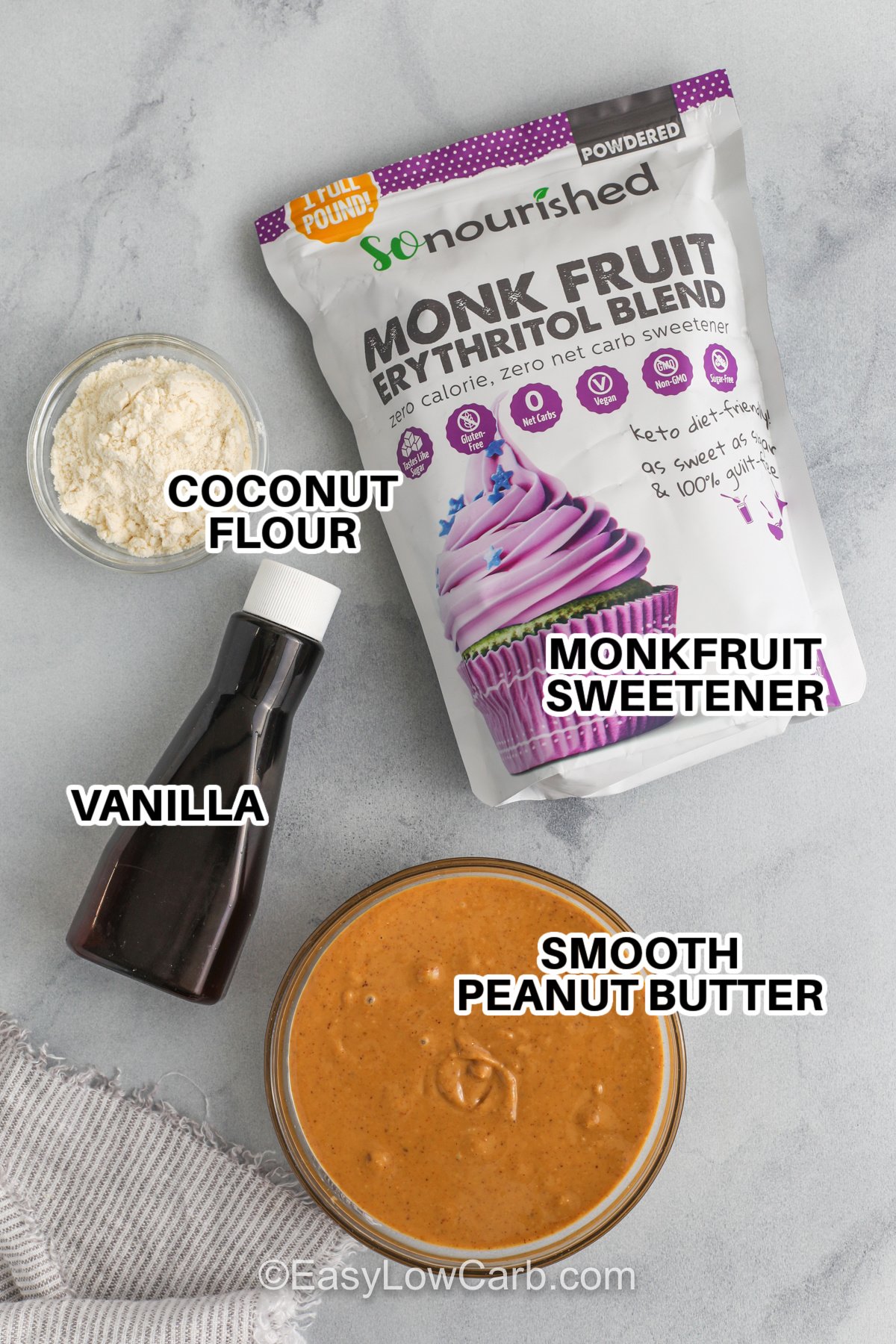 Ingredients to make keto peanut butter balls with labels, including monk fruit sweetener, coconut flour, vanilla, and smooth peanut butter