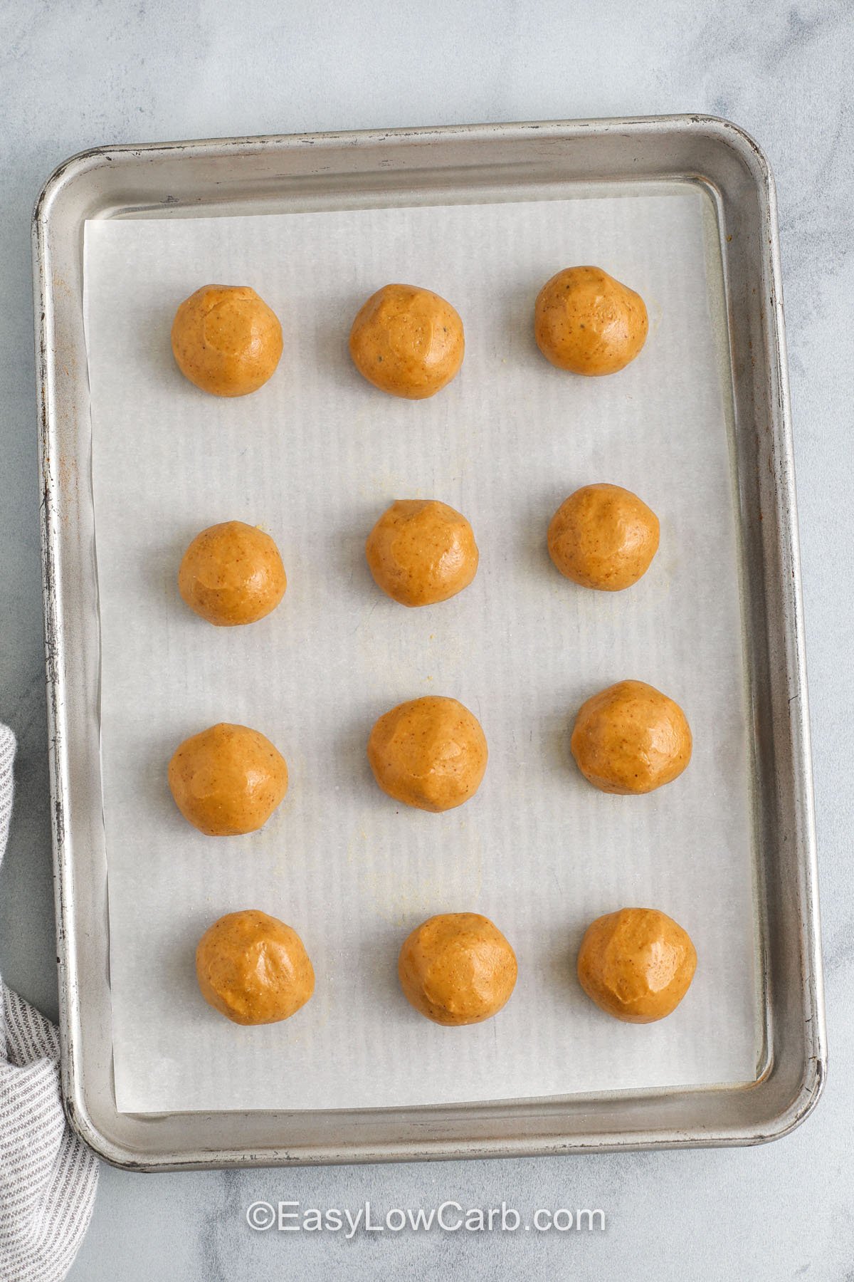 Keto peanut butter balls formed on a baking sheet