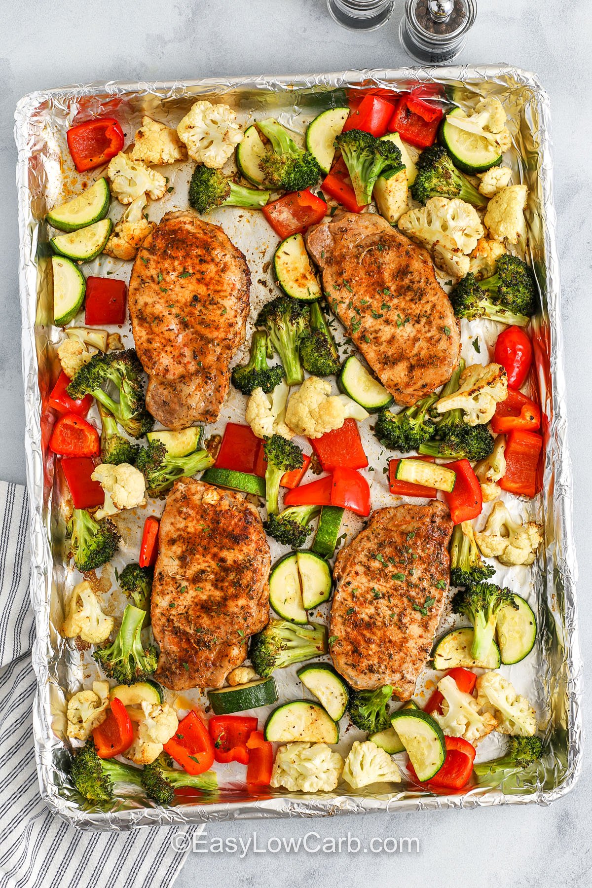Sheet pan pork chops are the ultimate one-pan dinner. They are juicy, flavorful, and ready in no time. The smoky paprika and garlic blend perfectly with tender roasted veggies like broccoli, cauliflower, zucchini, and bell pepper. It's an easy low-carb option that’s both filling and healthy. Cleanup is a breeze, and the whole family will love it. No fuss, no stress, just simple, wholesome food. #easylowcarb Pork chops and vegetables cooked on a baking sheet
