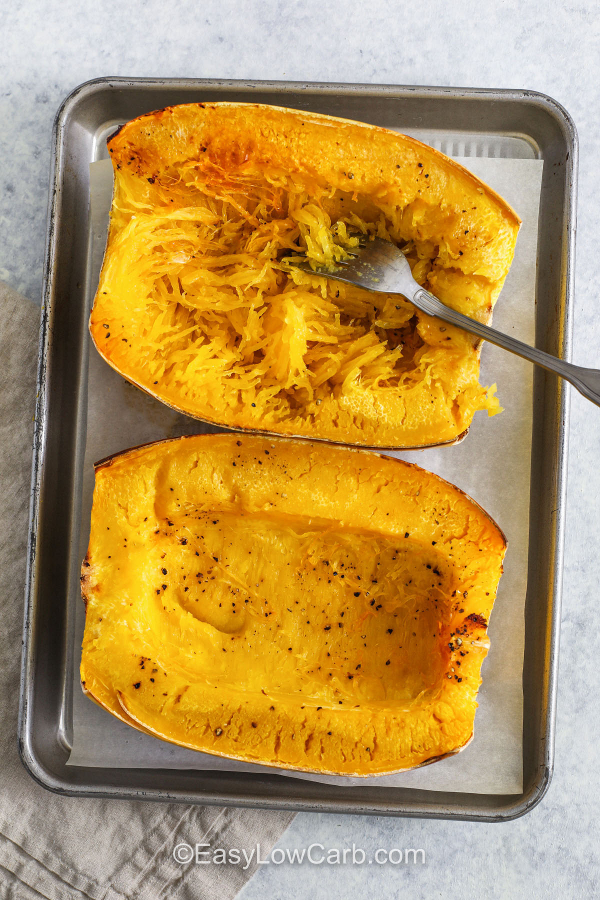 Spaghetti squash chicken Alfredo is a wholesome twist on traditional pasta night. Each roasted squash half becomes a flavorful bowl filled with creamy Alfredo sauce, tender chicken, and melted cheese. With fragrant garlic and herbs infusing every bite, this dish feels gourmet but is simple enough for busy evenings. Pure comfort, minus the carbs. #easylowcarb making spaghetti squash from cooked squash with a fork to make Spaghetti Squash Chicken Alfredo