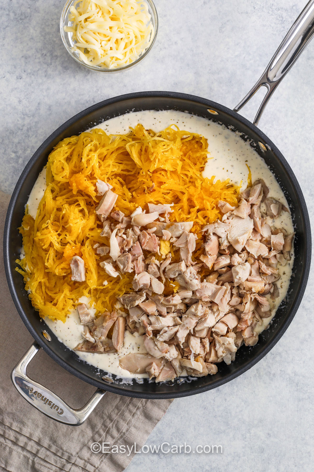 Creamy, cheesy, and full of flavor, spaghetti squash chicken Alfredo is a perfect blend of comfort and nutrition. The roasted squash provides a naturally sweet base, while the Alfredo sauce delivers rich decadence without heaviness. Parmesan and mozzarella combine for a creamy texture, and fresh herbs brighten every bite. A satisfying low-carb meal for any occasion. #easylowcarb ingredients in pan to make Spaghetti Squash Chicken Alfredo