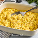casserole dish of Baked Scrambled Eggs with a plate of bacon