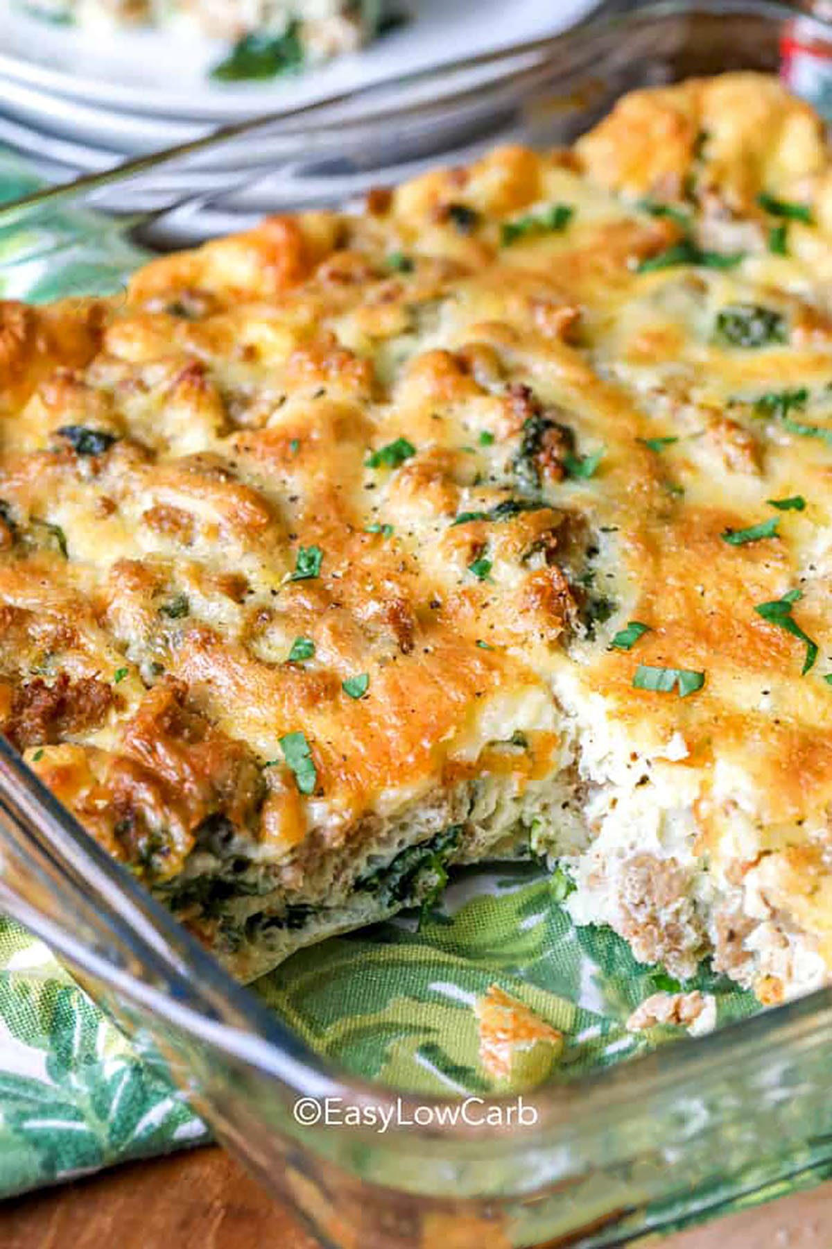 Create the best breakfast casserole with wholesome ingredients like eggs, fresh vegetables, cottage cheese, and bacon. The method of whipping egg whites gives the casserole a light, airy texture, and the flour helps bind the vegetables perfectly. This dish is versatile enough for gatherings or everyday meals and freezes beautifully. The cheesy finish makes each bite warm and delicious. #easylowcarb Best Breakfast Casserole in a dish with a piece taken out