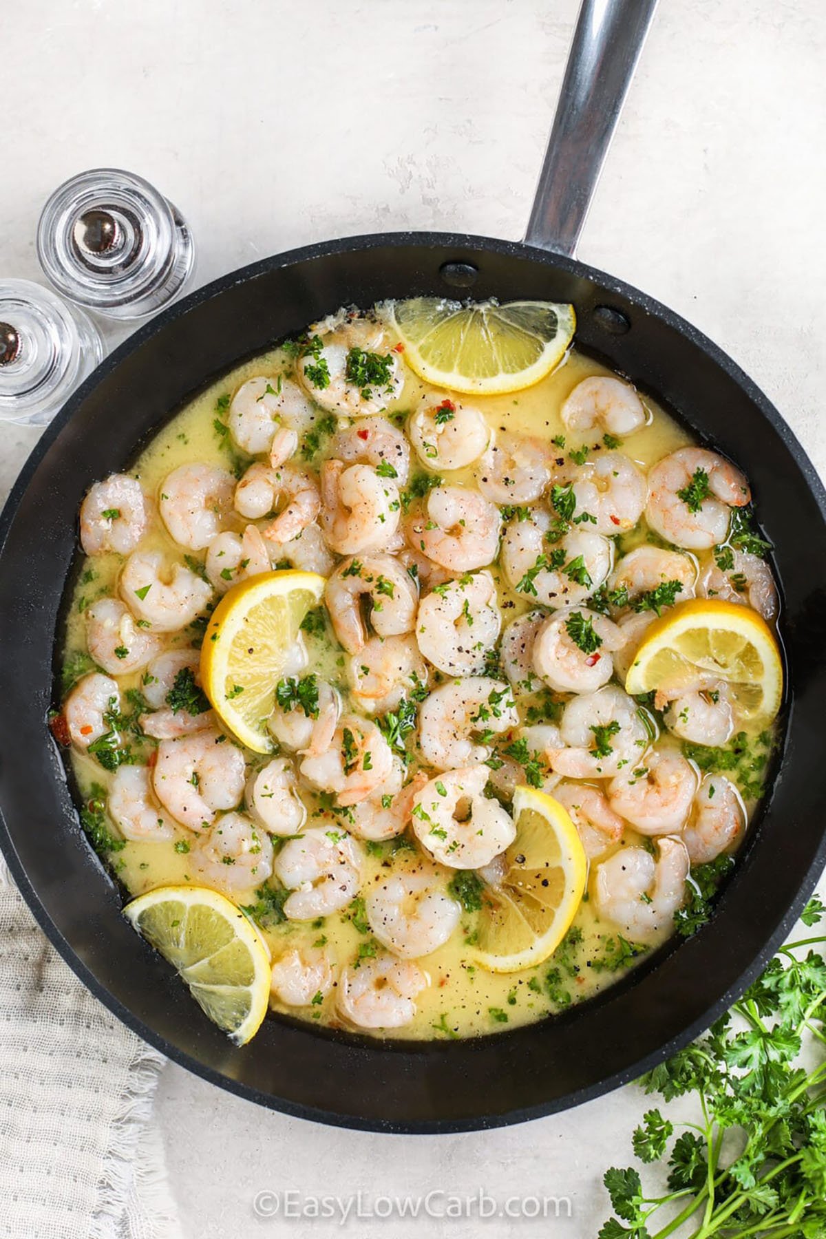 Easy shrimp scampi uses the technique of deglazing the pan with dry white wine after sautéing garlic and shrimp, which allows the browned bits to dissolve into a rich, flavorful sauce. The wine reduction adds depth without overpowering the natural sweetness of the shrimp. The dish is finished off with fresh parsley and a squeeze of lemon creating delicious flavor in every bite. #easylowcarb Easy Shrimp Scampi in a pan