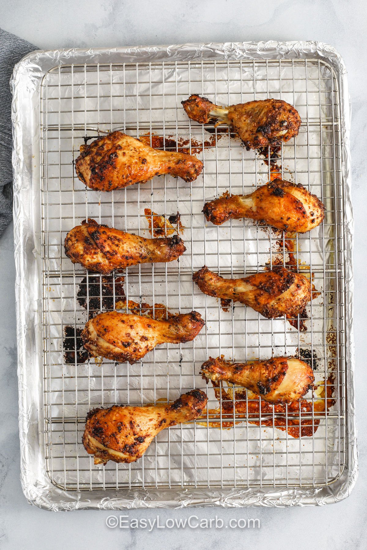 These oven-baked chicken drumsticks make a delicious low-carb dinner with minimal prep and bold smoky flavor. The combination of smoked paprika, garlic powder, and oregano creates a savory crust that crisps beautifully in the oven. This simple recipe is perfect for meal prep or busy nights when you want something satisfying without extra steps. Serve with low-carb sides like roasted broccoli or cauliflower mash for a complete meal. #easylowcarb top view of Oven Baked Chicken Drumsticks on sheet pan